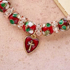Pulsera de cuentas rojas de esmalte con colgante de corazón cruzado