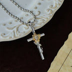 Collar con Colgante de Cruz en Tonos Plateados con Detalles Florales y de Hoja Dorados